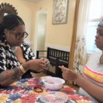 two women stringing beads